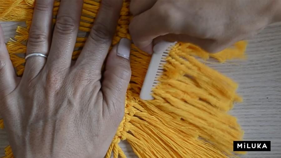 paso en el que se peina la cuerda para conseguir hilitos en el tutorial plumas de macramé en aro de madera