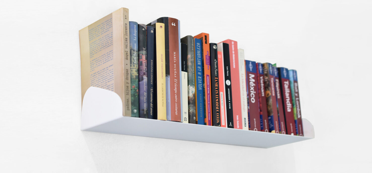Estante Geomi Book 60 blanco lleno de libros y colocado en la pared. Imagen de cabecera para el artículo de Nuevos estantes de pared de Miluka.